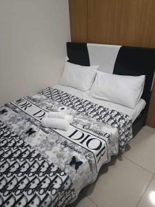 a bed with a black and white comforter on it at Sea Residences, S, Shell Janine's Residency in Manila