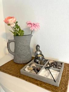 a tray with a statue and a vase with a flower at FeWo “ruhige Momente” in Waldkirch in Waldkirch
