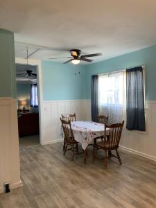 une salle à manger avec une table et des chaises et un ventilateur de plafond dans l'établissement Beachfront Cottage Best Location in Ocean View! cottage, à Norfolk