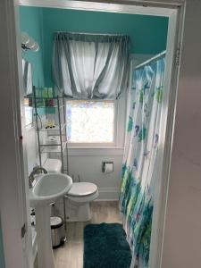 une salle de bain avec un lavabo et des toilettes et une fenêtre dans l'établissement Beachfront Cottage Best Location in Ocean View! cottage, à Norfolk 8 autres photos