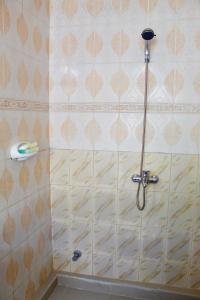 a shower in a bathroom with a toothbrush on the wall at The Island Stone Town hotel in Ngambo