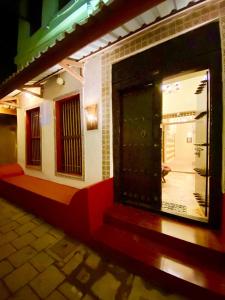 une porte d'entrée d'une maison avec une terrasse couverte dans l'établissement The Island Stone Town hotel, à Ngambo
