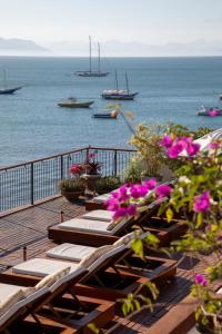 una terraza con sillas y vistas al océano. en Casas Brancas Boutique Hotel & Spa en Búzios
