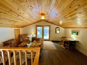 ein Wohnzimmer mit einem Sofa und einer Holzdecke in der Unterkunft Red River Aspen Retreat in Red River