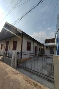 a house with a fence in front of it at OYO 93173 Khazanah Room Syariah in Yogyakarta