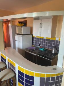 Una pequeña cocina con estufa y refrigerador. en Residencial Brila Mar, en Capão da Canoa