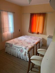Un dormitorio pequeño con una cama y dos ventanas. en Residencial Brila Mar, en Capão da Canoa
