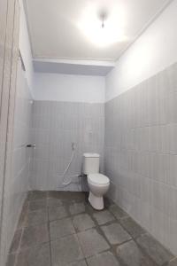 La salle de bains est pourvue de toilettes et d'une lumière au plafond. dans l'établissement OYO 93173 Khazanah Room Syariah, à Yogyakarta