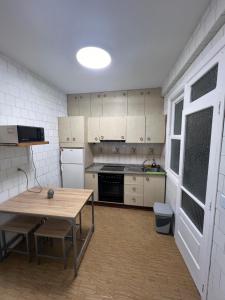 une cuisine avec une table en bois et une table sidx sidx sidx dans l'établissement Alojamiento Chloe, à Vigo 9 autres photos