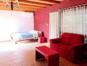 sala de estar con sofá rojo y cama en Entre naturaleza a 1 cuadra de la playa/Jacuzzi, en Salinas