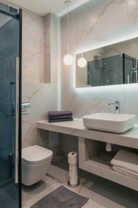 a bathroom with a sink and a toilet and a mirror at Apartament Pod 13 in Bielsko-Biała