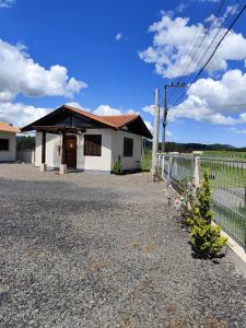 una casa blanca con una valla delante en Pousada Estrela Do Luar, en Urubici