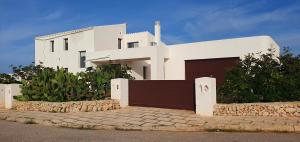 Una casa blanca con un garaje delante. en CASIOPEA, en Ciutadella