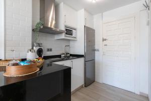uma cozinha com um balcão preto e uma porta branca em Apartamento costa del Sol em Benalmádena