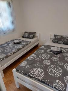 twee bedden met zwart-witte dekens in een kamer bij Unatime.Krupa in Bosanska Krupa
