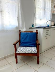 una silla con una almohada azul en la cocina en Katys Apartement Fiskardo, en Fiskardho