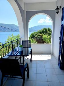 einen Balkon mit einem Tisch und Blick auf das Wasser in der Unterkunft Katys Apartement Fiskardo in Fiskardo