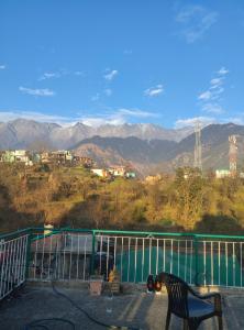 a chair on a balcony with a view of mountains at Shiva Home Stays in Dharamshala +22 photos