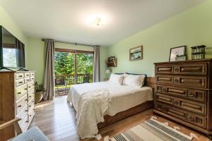 1 dormitorio con 1 cama, vestidor y ventana en Mountain Escape: with Sauna near Yellowstone, en Bozeman