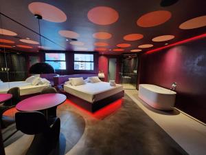 a hotel room with two beds and a tub and tables at Andar de Cima Suítes in Sao Paulo