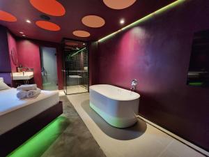 a bathroom with a bath tub in a room with pink at Andar de Cima Suítes in Sao Paulo