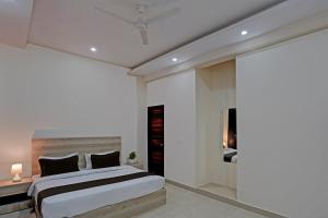 Schlafzimmer mit einem Bett und einer Glasschiebetür in der Unterkunft OYO Hotel Sunrise in Noida