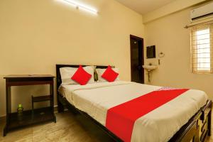 a bedroom with a bed with red and white pillows at OYO ROYAL HAVEN in Hyderabad