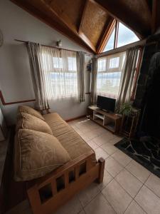 Schlafzimmer mit einem Bett, einem TV und Fenstern in der Unterkunft Terra Incognita in Ushuaia
