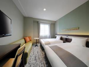 福島市にあるJR東日本ホテルメッツ福島のベッド2台とテレビが備わるホテルルームです。
