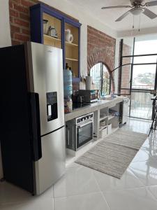 uma cozinha com um frigorífico de aço inoxidável num quarto em Casa Estrella em Puerto Vallarta