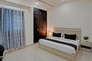 ein Schlafzimmer mit einem großen Bett und einem Fenster in der Unterkunft OYO Hotel Sunrise in Noida