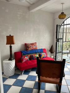 Casa Estrella في بويرتو فايارتا: غرفة معيشة مع أريكة حمراء وطاولة