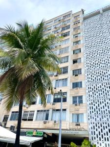 a palm tree in front of a large building at Beira Mar Copa in Rio de Janeiro