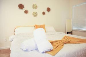 Una cama blanca con almohadas blancas y una manta. en NEW Charming Escape 3 BD King Suite East of Birmingham 