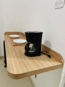 a black coffee maker sitting on a wooden table at Beira Mar Copa in Rio de Janeiro