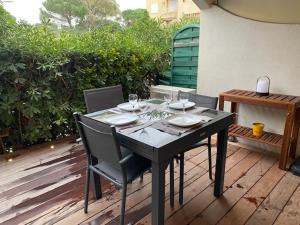 a black table with chairs and wine glasses on a patio at LE KALI in Cavalaire-sur-Mer