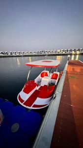 czerwono-biała łódź zaparkowana przy doku w obiekcie Luxury Villa 5 bedrooms with sea view and free boat w Fudżajrze