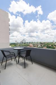 a table and chairs on a balcony with a view at Delightful Apt Two Minutes Away From La Galeria in Asuncion