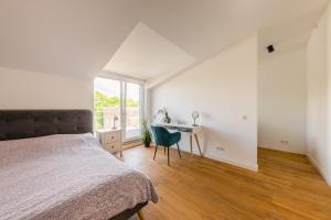 a bedroom with a bed and a desk and a window at Luxury Three-Bedrooms Apartment in Liepāja