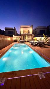 a large swimming pool in front of a house at Luxury Villa 5 bedrooms with sea view and free boat in Fujairah