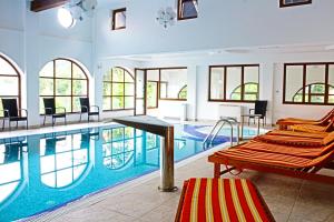a large swimming pool with chairs in a room at Hotel Esprit in Braşov