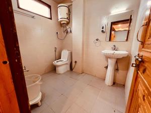 a bathroom with a toilet and a sink at Sita Hotel & Cottage, Manali in Manāli
