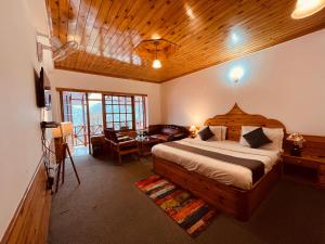a bedroom with a bed and a table in a room at Sita Hotel & Cottage, Manali in Manāli
