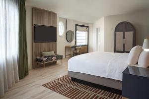 a bedroom with a bed and a flat screen tv at Hotel Vesper, Houston, a Tribute Portfolio Hotel in Houston