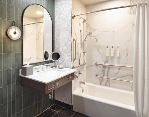 y baño con lavabo, bañera y espejo. en Hotel Vesper, Houston, a Tribute Portfolio Hotel en Houston