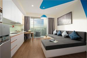 a living room with a couch and a kitchen at TUI BLUE Nha Trang in Nha Trang