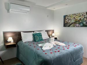 a bedroom with a bed with two swans on it at Apartamentos de Altitude Urubici in Urubici