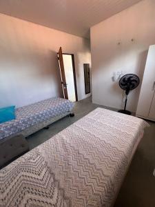 a bedroom with two beds and a fan at Casa nativa in Trairi +48 photos