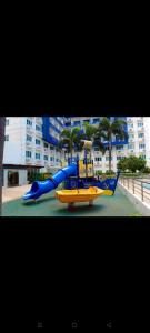 a blue and yellow water slide in front of a building at Sea Residences, S, Shell Janine's Residency in Manila
