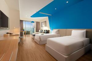a hotel room with two beds and a blue ceiling at TUI BLUE Nha Trang in Nha Trang